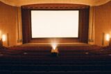Leerer DDR-Kinosaal der 1960er Jahre — warme Stimmung vor Filmbeginn