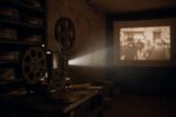 16mm-Filmprojektor im dunklen Archivraum — Lichtstrahl durch Staub, DDR-Dokumentarfilmarchiv