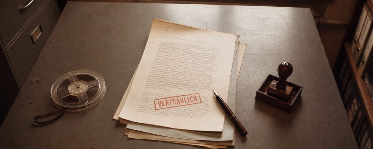 DDR-Behördenschreibtisch mit VERTRAULICH-gestempelten Dokumenten — Stasi-Ästhetik