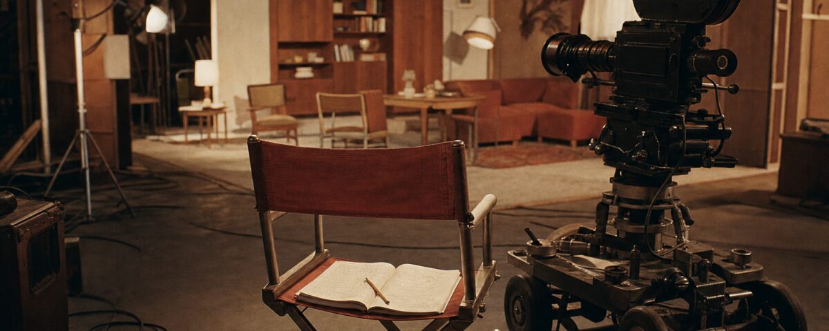 Leerer Regiestuhl und Kamera auf einem DEFA-Filmset der 1960er Jahre — Zeichen eines unterbrochenen Drehs